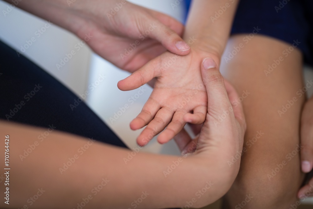 Cropped hands of female therapist examining palm while boy Cropped hands of female therapist examining palm while boy