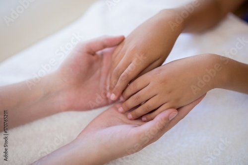 High angle view of female therapist examining hands on white