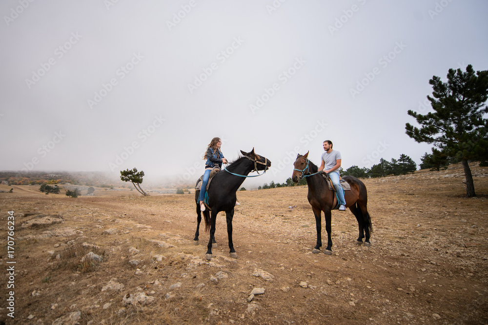 Couple in love on horsebacks outdoors Couple in love on horsebacks outdoors