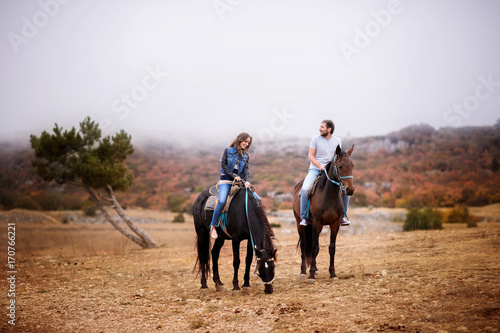 Couple in love on horsebacks outdoors © Inna Darda