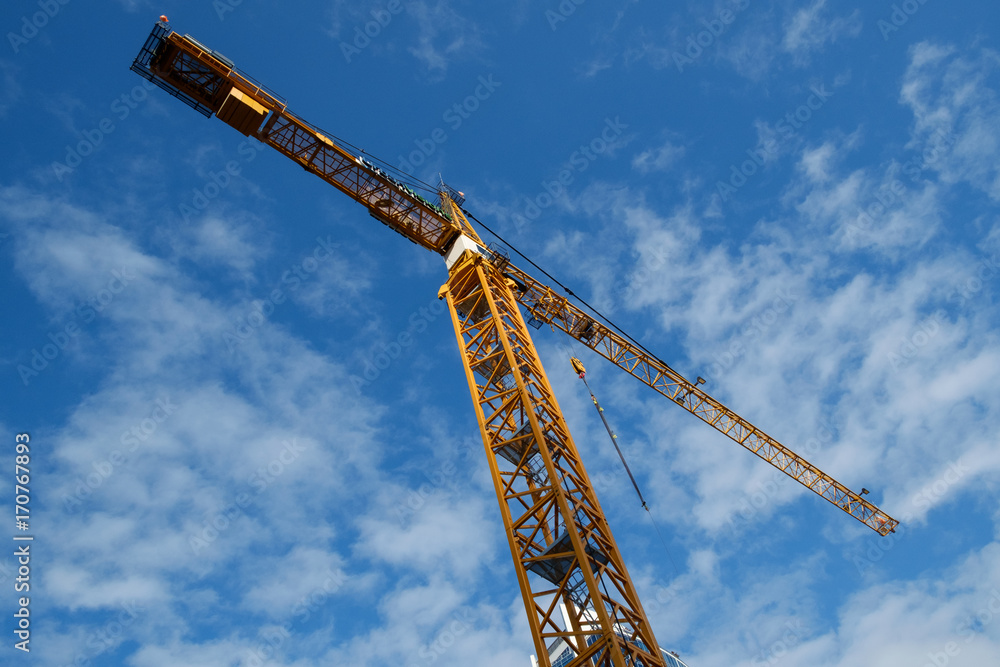 Yellow construction crane against blue sky Yellow construction crane against blue sky