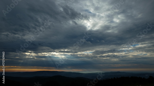 Cloudy sky with sun rays during sunrise in Romania