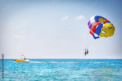 Parachuting in Turkey. Parasailing with boat over sea in Alanya in beautiful summer day. Tropical beach vacation. photo