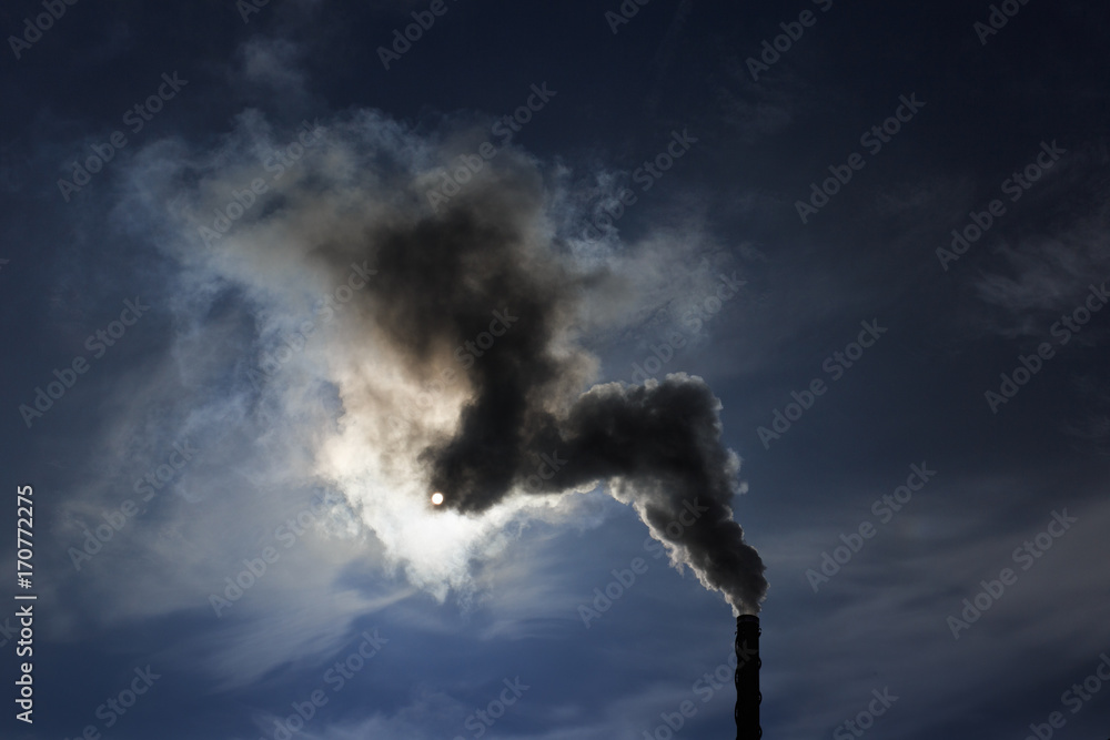 Air pollution by smoke coming out of factory chimney