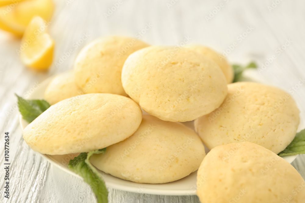 Plate with homemade lemon cookies on wooden table Plate with homemade lemon cookies on wooden table