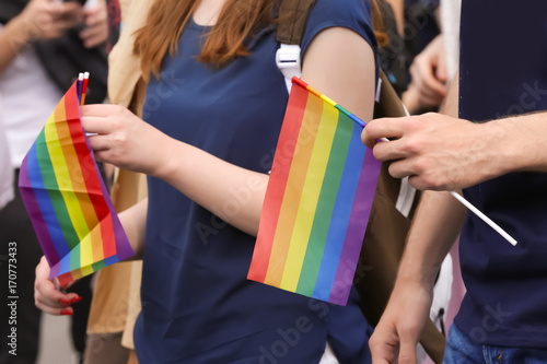 Concept of sexual minority. People holding gay rainbow flags outdoors