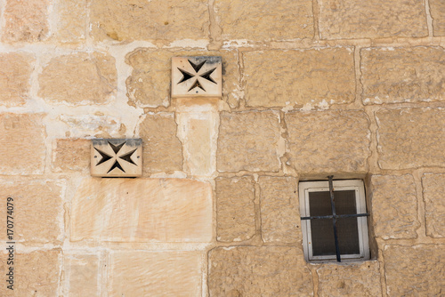 Fototapeta Naklejka Na Ścianę i Meble -  Ventilator on a stone wall. Maltese cross