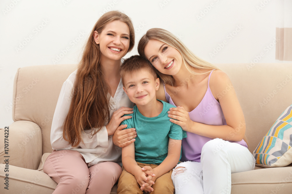 Happy lesbian couple with foster son at home. Adoption concept Happy lesbian couple with foster son at home. Adoption concept