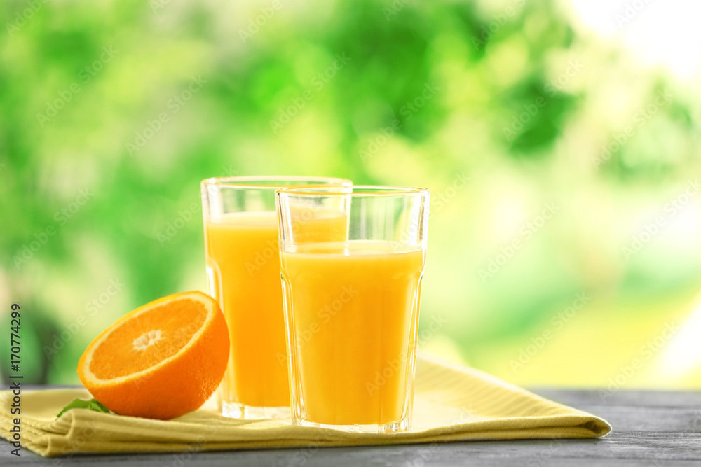 Fototapeta premium Glasses with delicious orange juice on table
