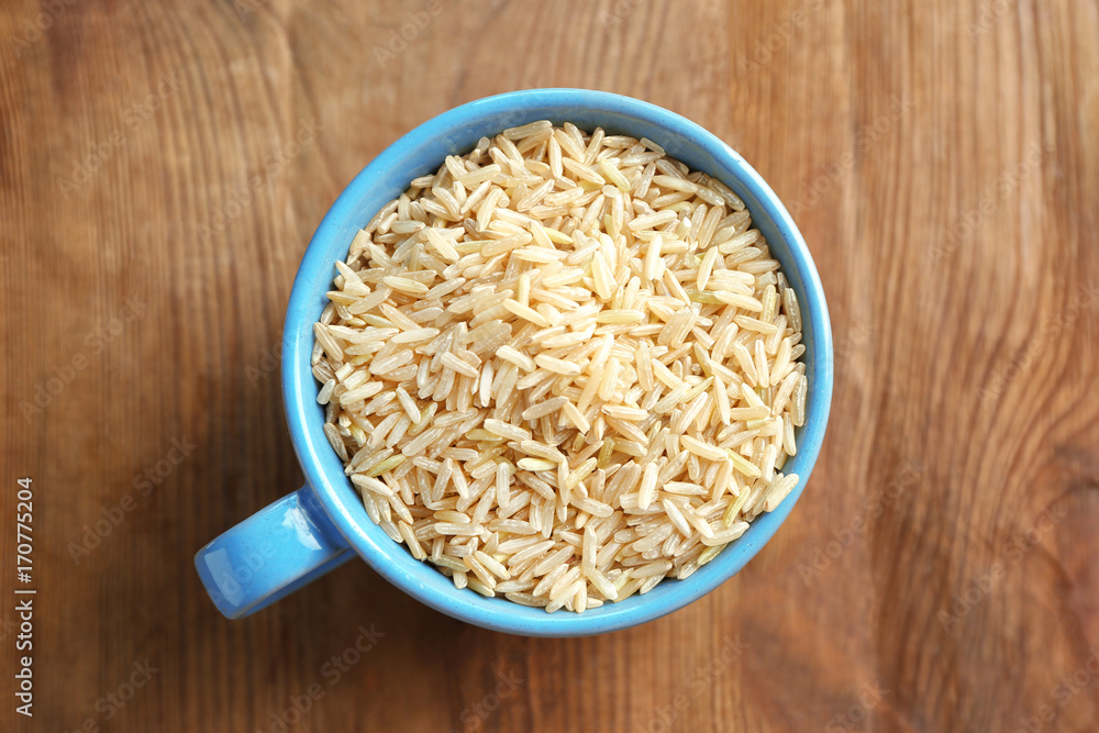 Cup of long grain brown rice on table Cup of long grain brown rice on table