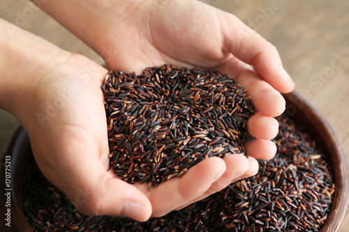 Female hands full of brown grain rice