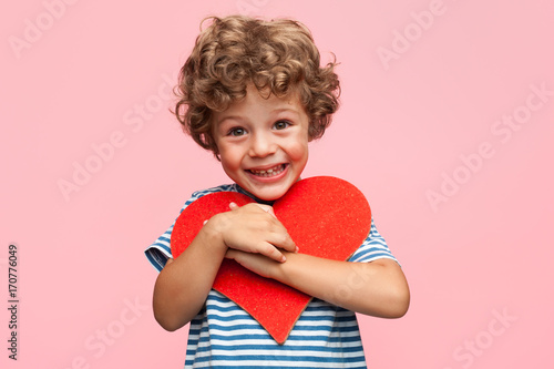 Charming boy posing with heart photo