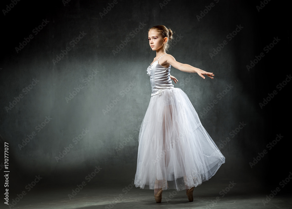 Ballet. Image of a flexible cute ballerina dancing in the studio. Beautiful young dancer. The girl is studying ballet.