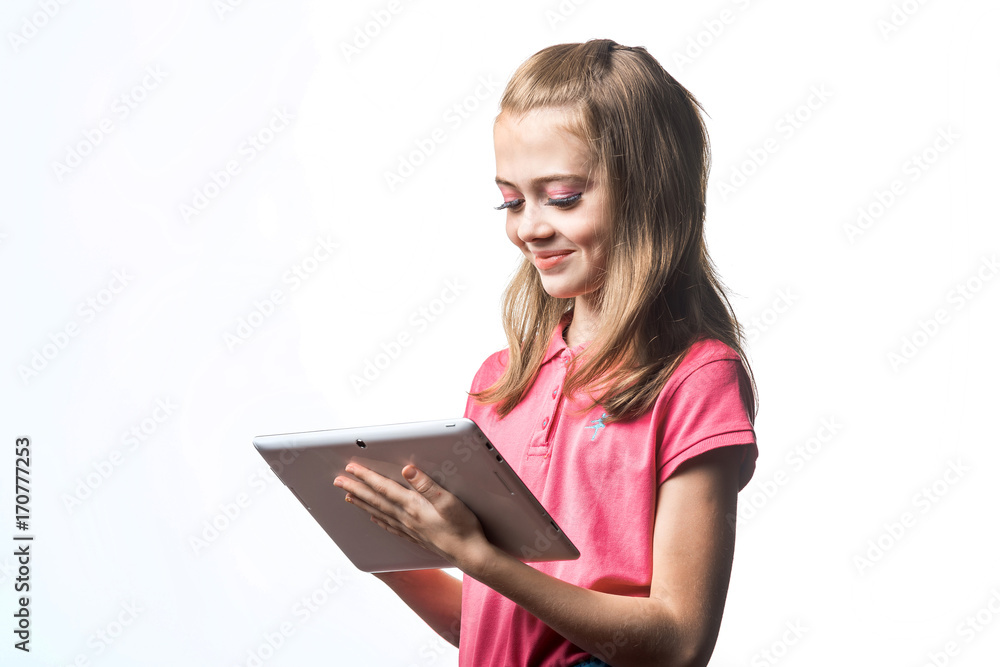 Little girl with a tablet computer on a white background. Emotions and smile of the child.