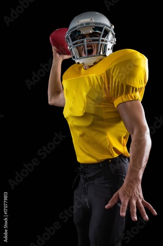 Energetic American football player holding a ball in one hand