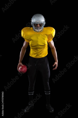 American football player holding a ball in one hand