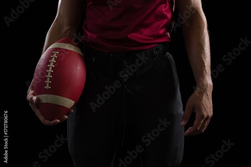 American football player holding a ball in one hand © WavebreakMediaMicro