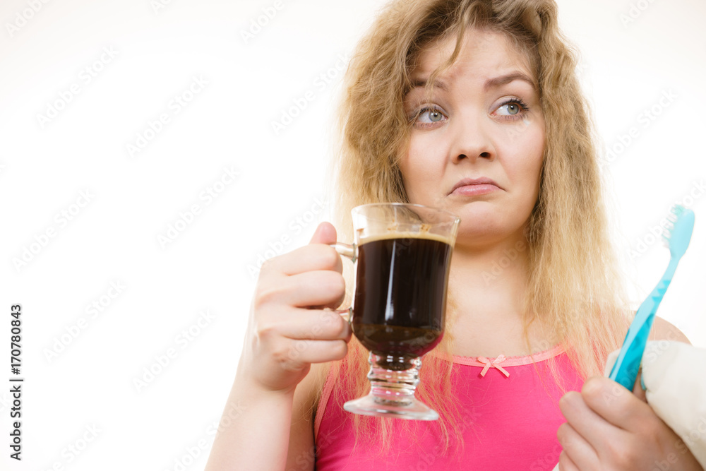 Tired woman holding toothbrush and coffee Tired woman holding toothbrush and coffee