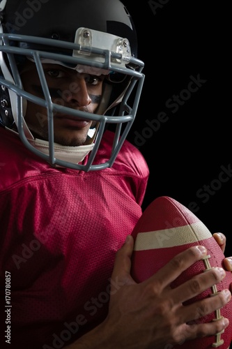 American football player holding a football with both his hands © WavebreakMediaMicro