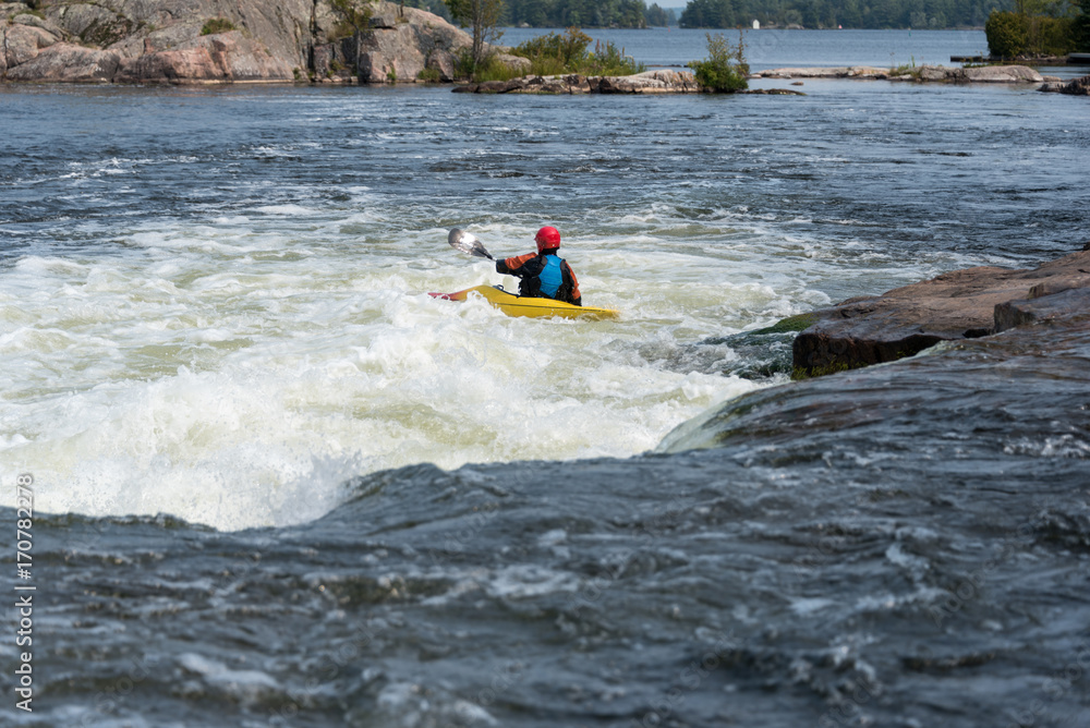 Kayaker running short rapids