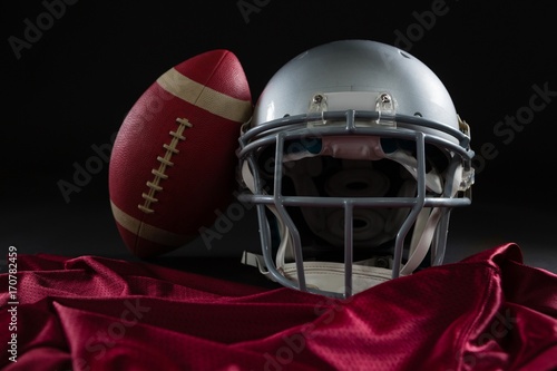 Close-up of American football jersey, head gear and football