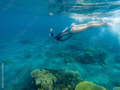 Woman swimming in blue sea. Snorkeling girl in full-face snorkeling mask.