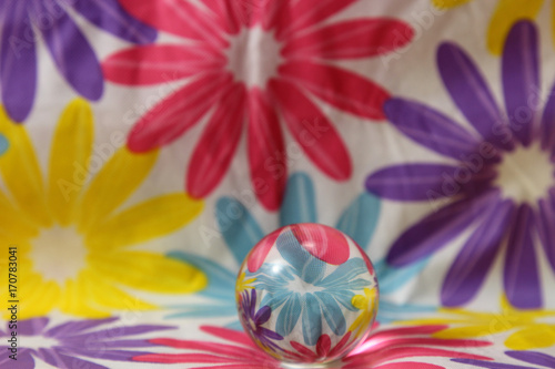 A still life of a glass sphere  with flowers