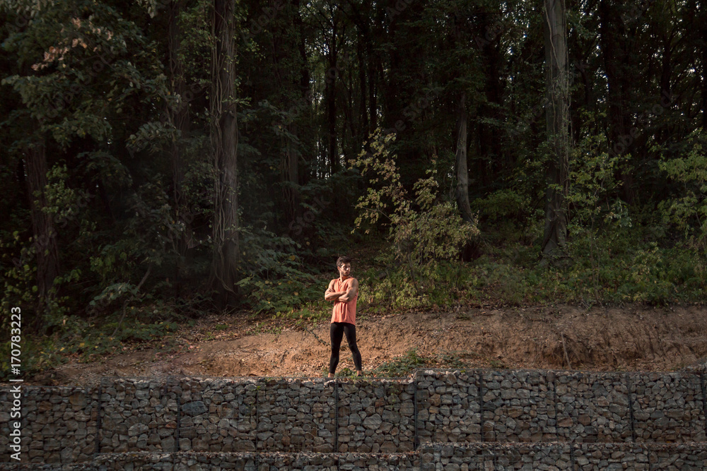 one young adult man, standing posing, wilderness, jungle portrait, sport clothes, outdoors nature forest one young adult man, standing posing, wilderness, jungle portrait, sport clothes, outdoors nature forest
