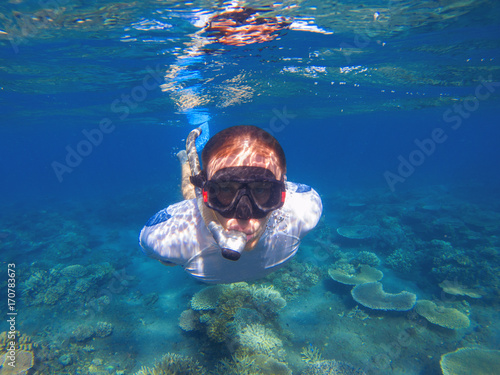 Young man underwater portrait. Male snorkel in tropical lagoon undersea photo