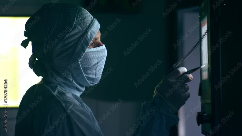 Pharmaceutical worker operating production line. Factory worker using touch screen panel. Medical worker face. Engineer working with touchscreen technology at modern factory Pharmaceutical worker operating production line. Factory worker using touch screen panel. Medical worker face. Engineer working with touchscreen technology at modern factory