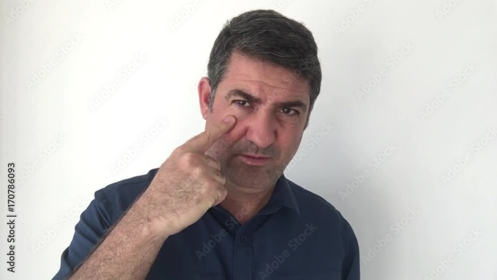 Italian man demonstrate I am watching you sign of Italian hand gestures. Body language and facial expression communication concept. Real people. copy space Italian man demonstrate I am watching you sign of Italian hand gestures. Body language and facial expression communication concept. Real people. copy space