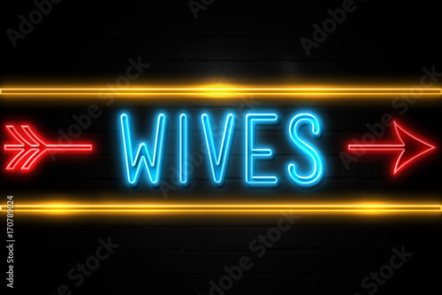 Wives - fluorescent Neon Sign on brickwall Front view