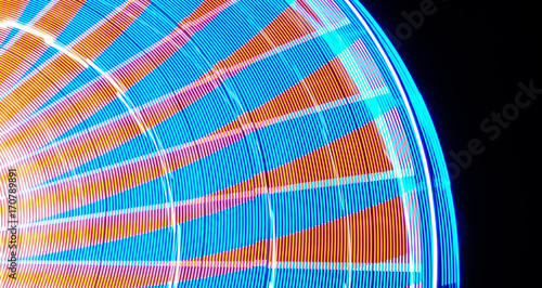 Abstract moving blur of ferris wheel at night