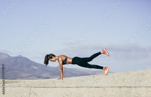 Muscular woman doing core exercise outdoors