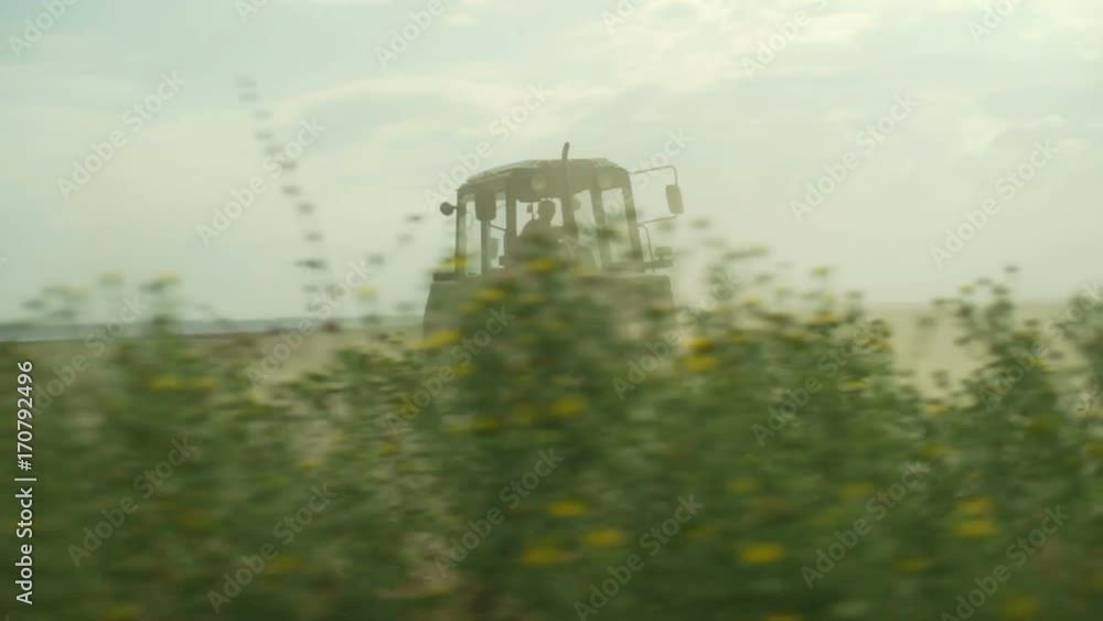 Combine harvester gathers dry beveled grass on empty field rapid slow motion Combine harvester gathers dry beveled grass on empty field rapid slow motion
