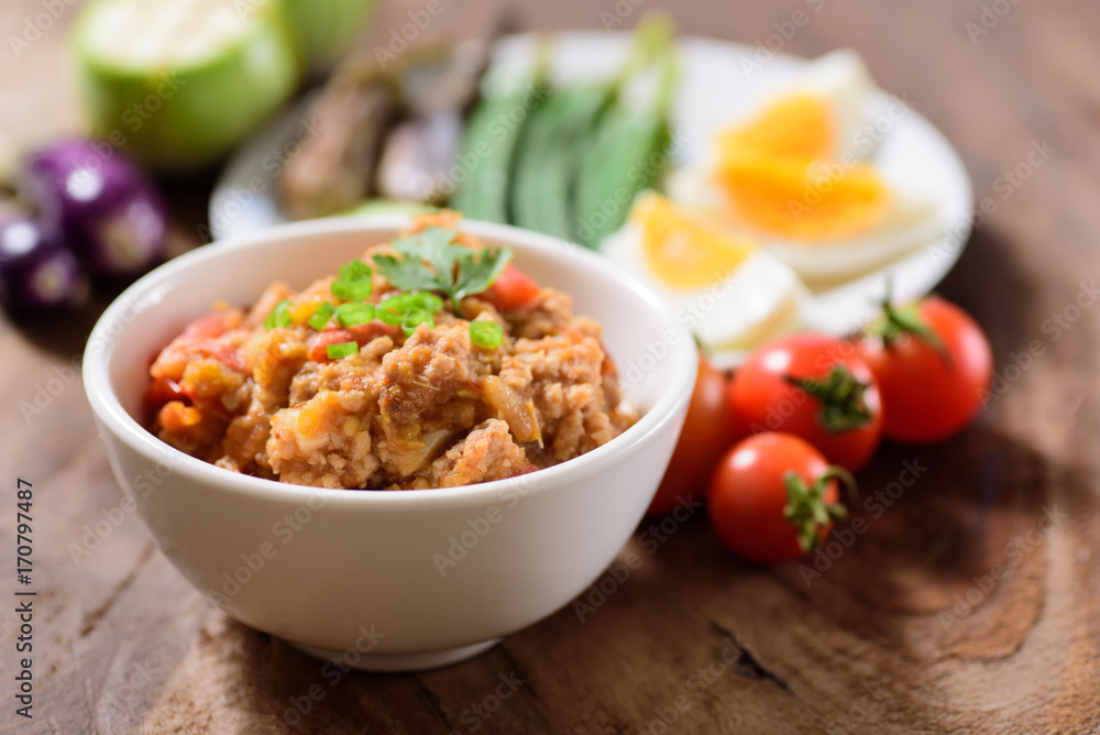 Thai Northern food (Nam Prik Ong) with vegetables on wooden background,spicy tomato with pork,red chili dip,NorthernThai dipping sauce Thai Northern food (Nam Prik Ong) with vegetables on wooden background,spicy tomato with pork,red chili dip,NorthernThai dipping sauce