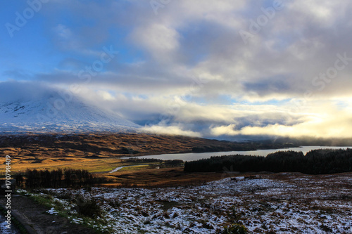 Incredible cloudscape during sunset in the Scottish Highlands with sun glowing through the clouds.