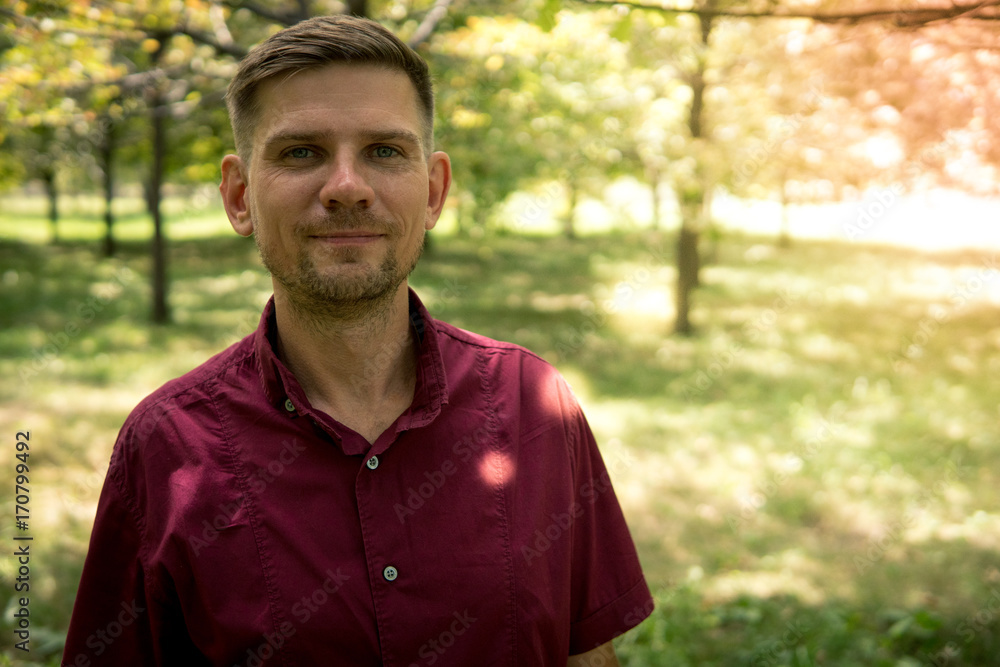 Young attractive man in the park in summer. Portrait of man Young attractive man in the park in summer. Portrait of man
