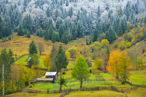 Two seasons, a rural landscape from a mountain region with autumn colors and some fresh snow