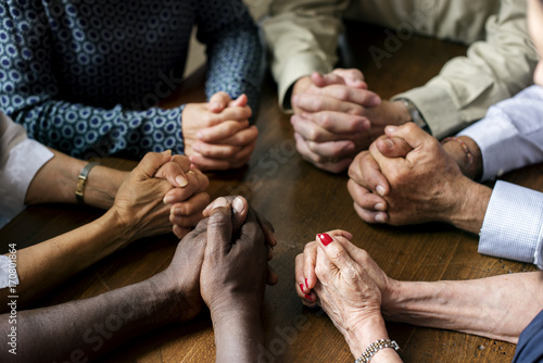 Canvas Print Group of interlocked fingers praying together
