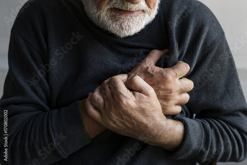 Closeup of elderly man having heart attack chest pain