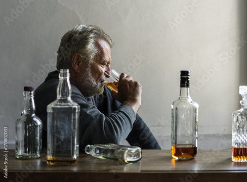 Elderly man sitting drinking whiskey alcoholic addiction bad habit photo
