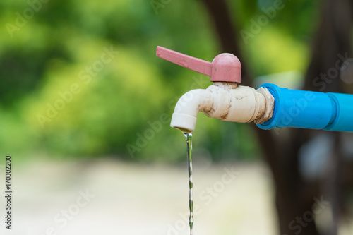 Water drop from old chrome faucet and water pipeline.