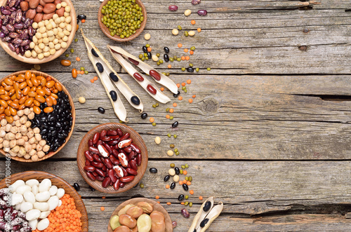 Various dried legumes in bowls on a wooden table. Copyspace background.Top view. photo