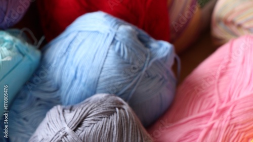 Multi colored yarn ball on a skein, background blurry