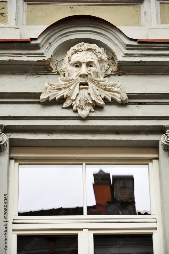 Fototapeta premium Decorative sculpture of the old man's head above the window. Vilnius, Lithuania.