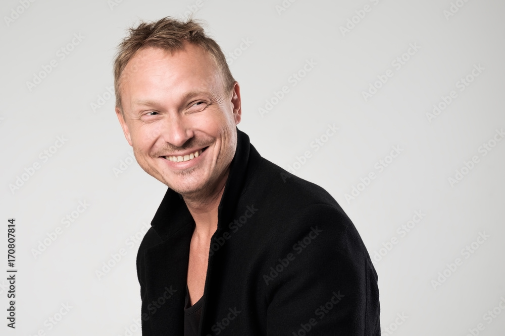 Smiling young man in black clothesstanding against white background Smiling young man in black clothesstanding against white background