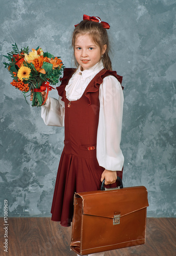 Schoolgirl with school knapsack and flowers photo