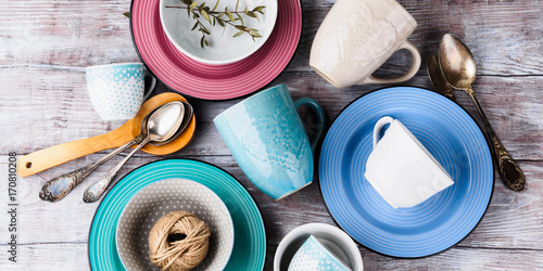 Ceramic crockery tableware on wooden background. Pastel vintage color bowls, dishes, cups