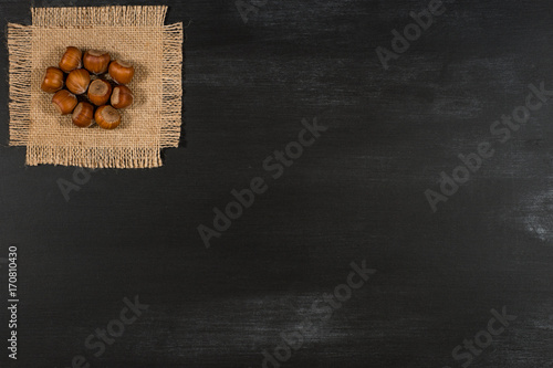 Hazelnuts on a black chalkboard.